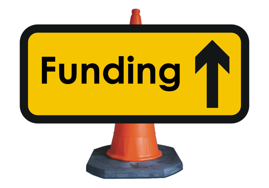 traffic sign that says funding in front of traffic cone